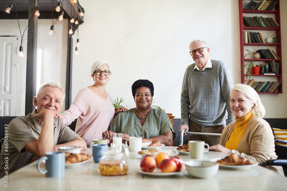 Portrait of diverse group of smiling senior people looking at camera in nursing home