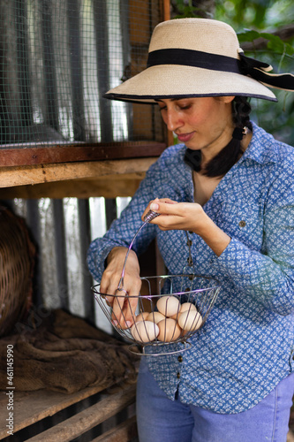 Peasant woman in Latin America, in a chicken coop. collecting eggs from their chickens. Woman in the chicken pen taking eggs. showing her hen and her eggs.