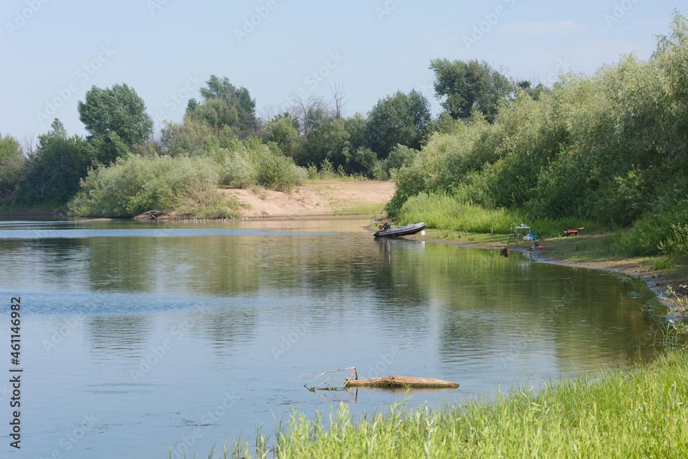 Boat with a motor on the river bank. Fishing in  summer