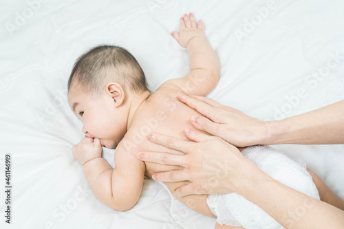 Cute baby massage back in bed, child and health concept.Baby massage and exercises.