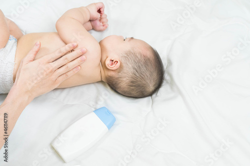Selective focus Mother are applying a lotion cream on the baby body after bath. Baby Care Concept.massage for baby. concept cleaning wipe, pure, clean.