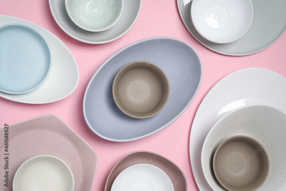 Different plates and bowls on pink background, flat lay Different plates and bowls on pink background, flat lay
