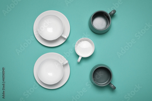 Different cups on turquoise background, flat lay