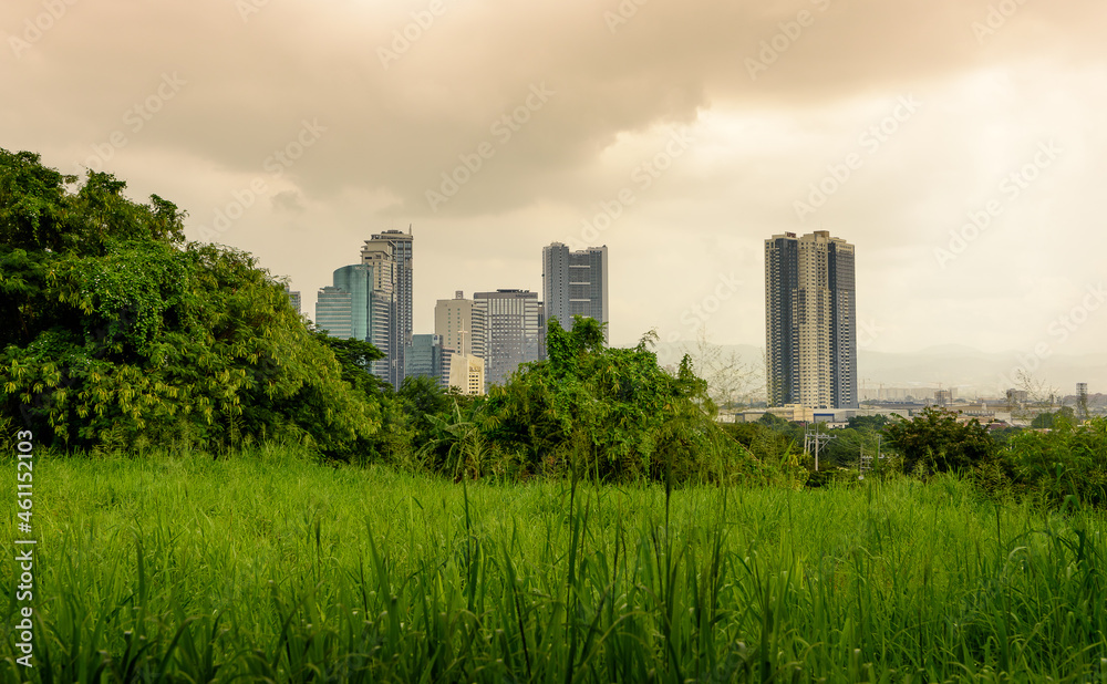 Obraz premium Metro Manila skyline as seen from Quezon City with colorful clouds and rain.