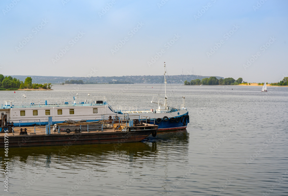 The bank of the Volga River with an old barge used as a berth