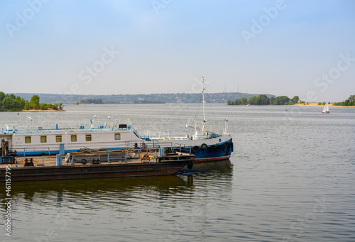 The bank of the Volga River with an old barge used as a berth © Sergey