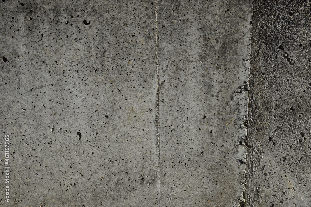 A textured concrete wall with pit marks and weathering