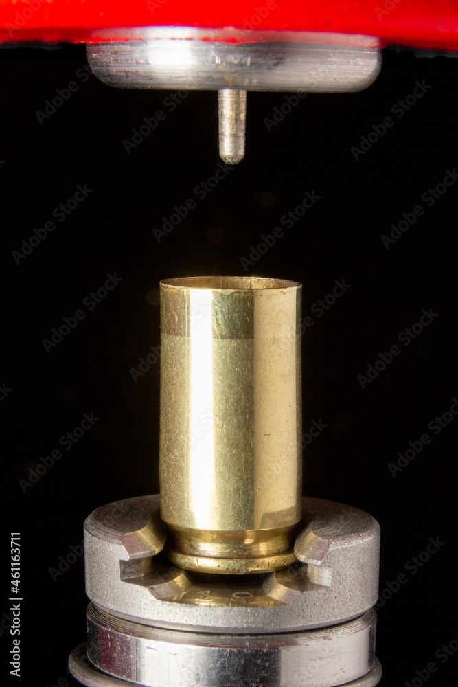 Reloading 9mm cartridge: decapping of brass casing with full length size die on press. Reloading 9mm cartridge: decapping of brass casing with full length size die on press.