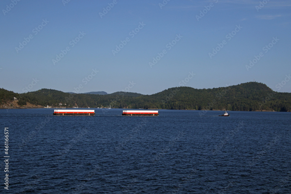 Obraz premium A tugboat pulling two barges
