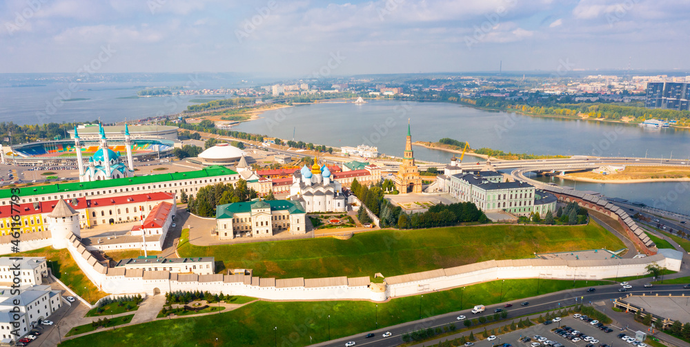 Aerial view of large Russian city of Kazan with embankment along Volga river and ancient walled Kremlin on green hill in summer, Tatarstan .