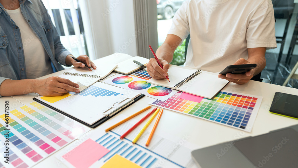 a couple of designers choosing the right colour fitting the concept from the spectrum a couple of designers choosing the right colour fitting the concept from the spectrum