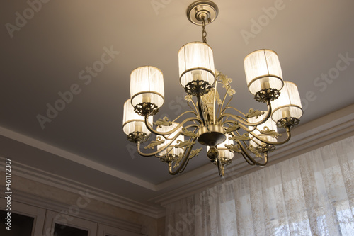 chic chandelier in a country house with bulges and contours. beautiful lamp on the ceiling