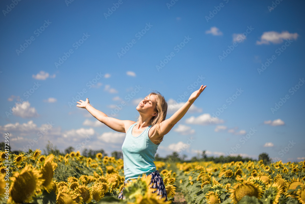 Beauty sunlit woman on yellow sunflower field Freedom and happiness concept. Happy girl outdoors Beauty sunlit woman on yellow sunflower field Freedom and happiness concept. Happy girl outdoors