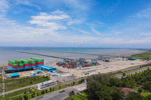 Aerial top view container cargo ship, in import export business logistic and transportation in Kuala Tanjung Port, Batubara, North Sumatra, Indonesia.