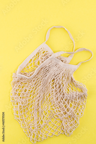 Reusable cotton and mesh eco bags for shopping on yellow background with copy space. Zero waste concept. No plastic