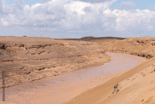 Nature and landscapes of seasonal river and valleys in dasht e lut or sahara desert with cloudy sky