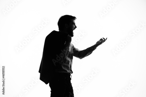 The man in a suit gun in the hands of the emotions silhouette light background