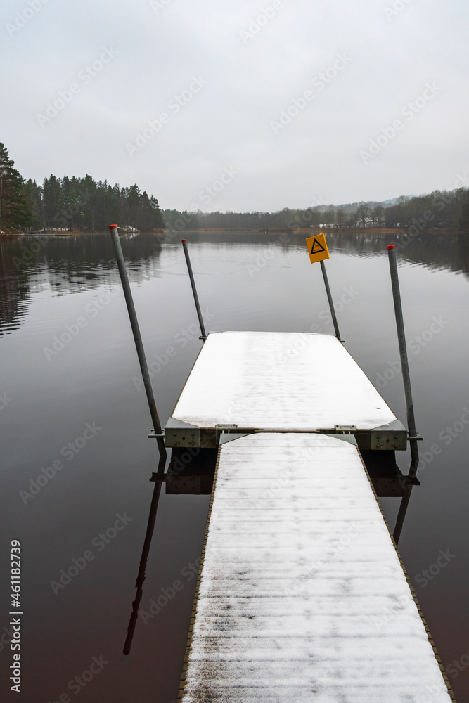 Fototapeta premium Snowy jetty at a lake in bad weather
