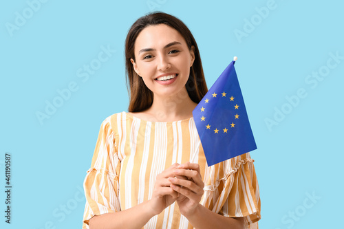 Young woman with flag of European Union on color background photo