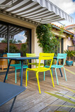 Salon de jardin coloré sur une terrasse en bois.