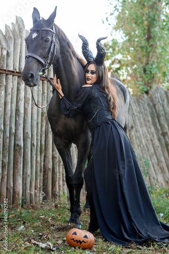Beautiful woman dressed for Halloween with horse outdoors