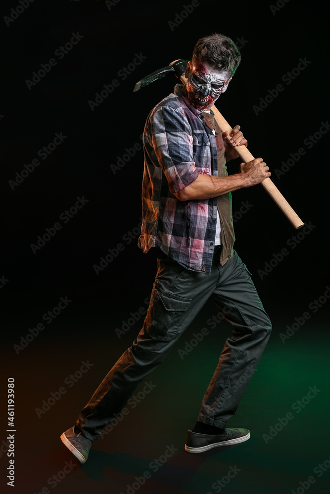 Obraz premium Scary zombie with pick-axe on dark background