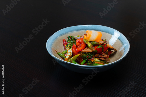 Salad with meat and vegetables on a black background