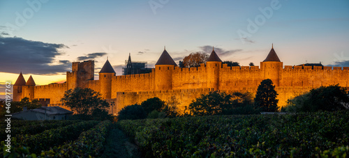 Lighted Carcassonne fortification walls seen from vineyards surrounding the city-Panorama. © Mike Mareen