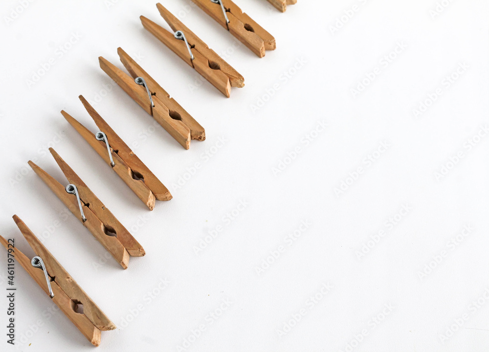 wooden clothespins lie in a row on a white background. Space for text wooden clothespins lie in a row on a white background. Space for text