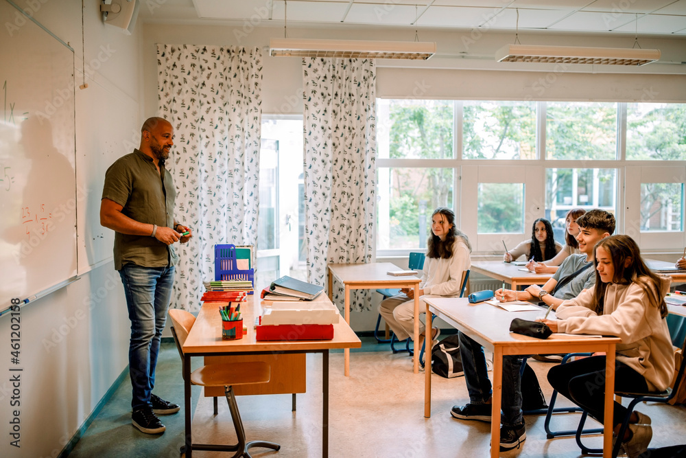 Male professor teaching to student in classroom Male professor teaching to student in classroom