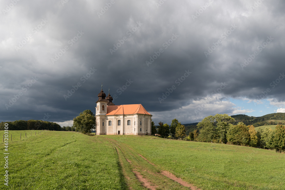 Church of St. Margaret from the 18th century near Šonov. Beautiful church chapel in middle of fields in czech countryside broumovsko region with hills of broumov walls on background. Czech landscape.
