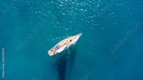 Drone aerial view of a sailing boat on a blue ocean sea waters. © astrosystem