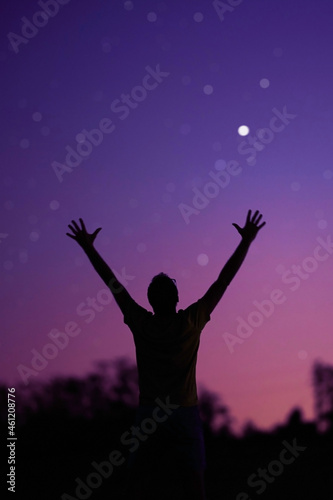 Silhouette of a man and countryside under the starry skies.