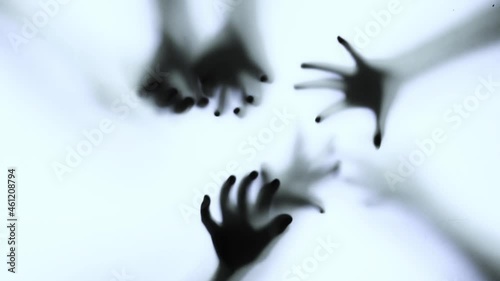 Silhouette of a zombie hand on white background in slow motion
 photo