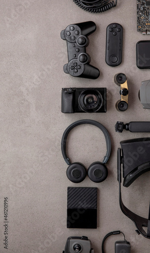 Overhead flat lay of black technology devices and gadgets on a grey background photo