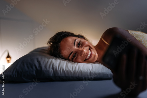 Adult woman, writing a text at night.