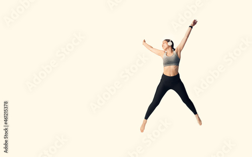Beautiful sportswoman is jumping high like a star. Full body length photo.