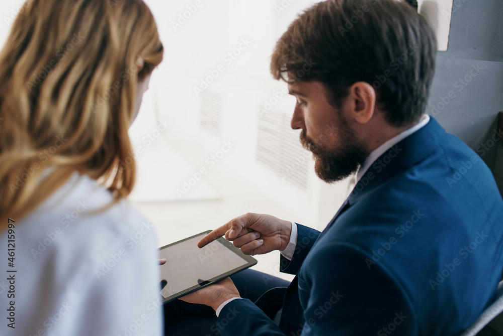 man and woman in business suits communicate with the tablet officials teamwork
