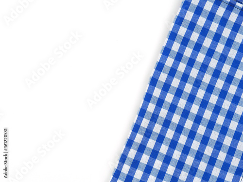 Top view, close-up of blue and white checkered fabric or napkin on white table background. Concept kitchen utensils and tableware. Top view, flat lay with copy space..