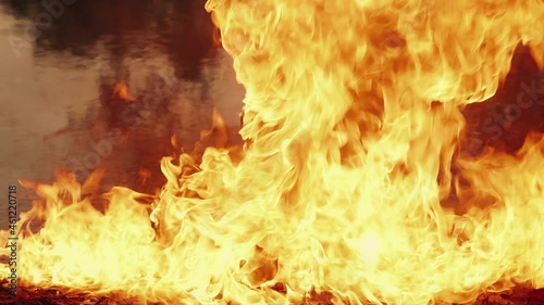 Column of fire on the water surface, on the border with the earth. Ignition of fuel and oil on water. The concept of ecology and environmental pollution