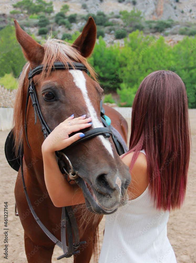 Obraz premium young girl hugs brown horse 