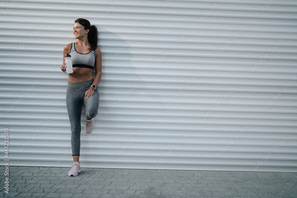Beautiful athlete woman in sportswear. Young thristy woman training outdoors. Beautiful athlete woman in sportswear. Young thristy woman training outdoors.