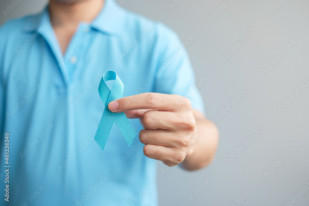 November Prostate Cancer Awareness month, Man in blue shirt with hand holding Blue Ribbon for supporting people living and illness. Healthcare, International men, Father and World cancer day concept