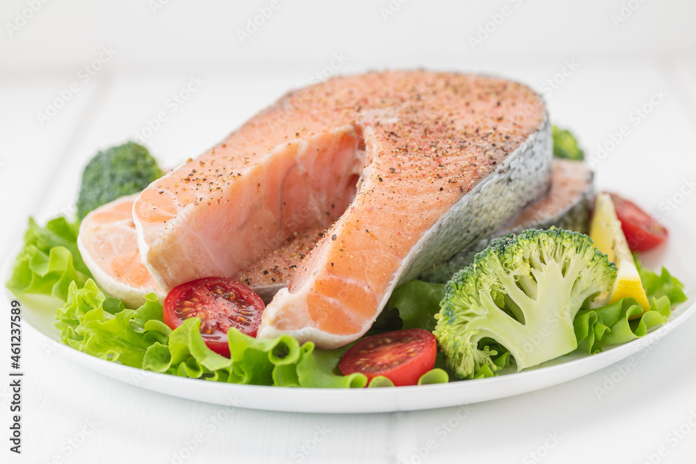 Raw uncooked salmon steak with fresh vegetables. Raw uncooked salmon steak with fresh vegetables.