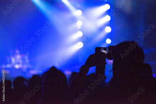 Hand holding smart phone at live music festival