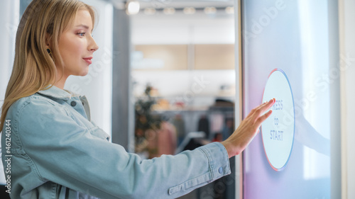 Tableau sur toile Beautiful Female Customer Using Floor-Standing LCD Touch Display while Shopping in Clothing Store