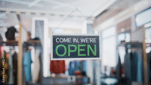 Shot of a Sign "We are Open" on a Glass Door of a Stylish Clothes Store. Blurred Background of a Shop, Supermarket, Bar or Another Company, Business.