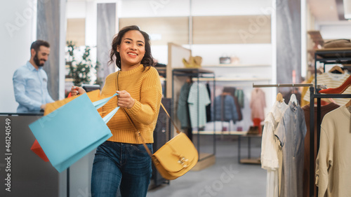Clothing Store: Young Woman with Shopping Bags in Happy Mood Leaves Shop, Smiling, Spinning and Dancing. Fashion Shop with Designer Brands.