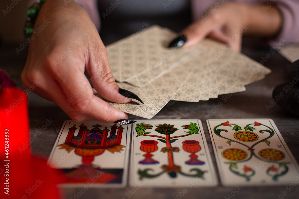 Fortune teller reading a future by tarot cards on rustic table Fortune teller reading a future by tarot cards on rustic table