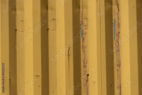 Garage corrosion on a rough striped metal wall or floor, scratches, air holes, rusty house fence, holes, dents, pins.